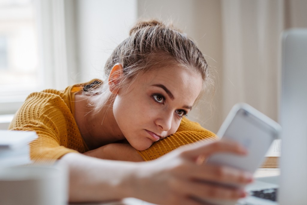 Girl looking at phone, doomscrolling social media. 